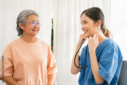 Medical doctor woman wearing stethoscope alking consultation about treatment with Asian mature woman, Healthcare and nursing service
