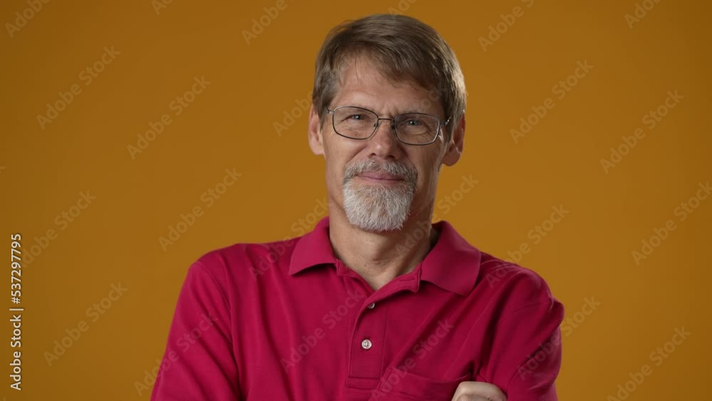 Smiling bearded mature man 50s 60s years old wearing red shirt isolated on solid yellow background studio. People sincere emotions lifestyle concept. Looking camera. Smiling bearded mature man 50s 60s years old wearing red shirt isolated on solid yellow background studio. People sincere emotions lifestyle concept. Looking camera.