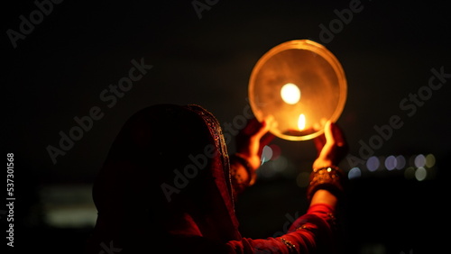 Woman hand holding Karwa Chauth strainer for the Karwa Chauth celebration on the night. Karwa Chauth strainer and Diya oil lamps for the Karwa Chauth celebration on the night photo