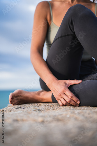 Unrecognizable woman resting while sitting during a yoga session.