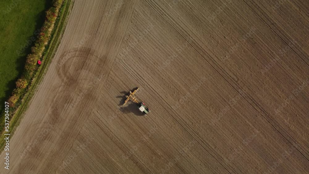 A tractor rolling a ploughed field in Autumn. From directly above. Aerial A tractor rolling a ploughed field in Autumn. From directly above. Aerial