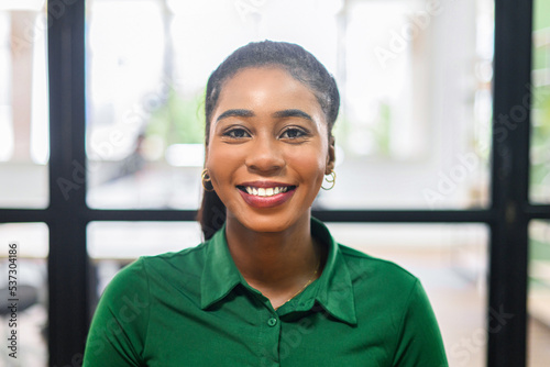 Billede på lærred Portrait of a charming african-American businesswoman wearing green smart casual shirt smiling at the camera