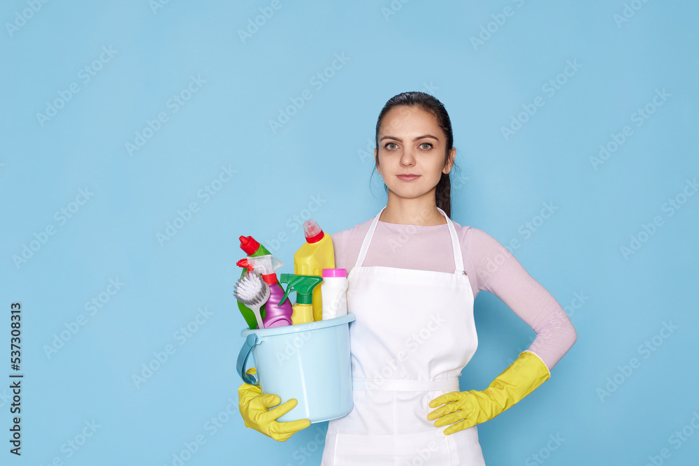 woman in gloves holding bucket with cleaning supplies woman in gloves holding bucket with cleaning supplies