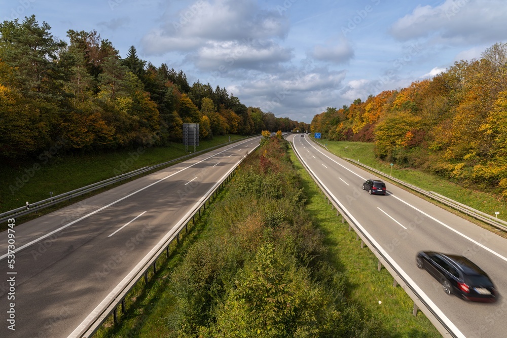 Autumn highway - cars are driving fast over a german Autobahn with colorful fall colors. Autumn highway - cars are driving fast over a german Autobahn with colorful fall colors.