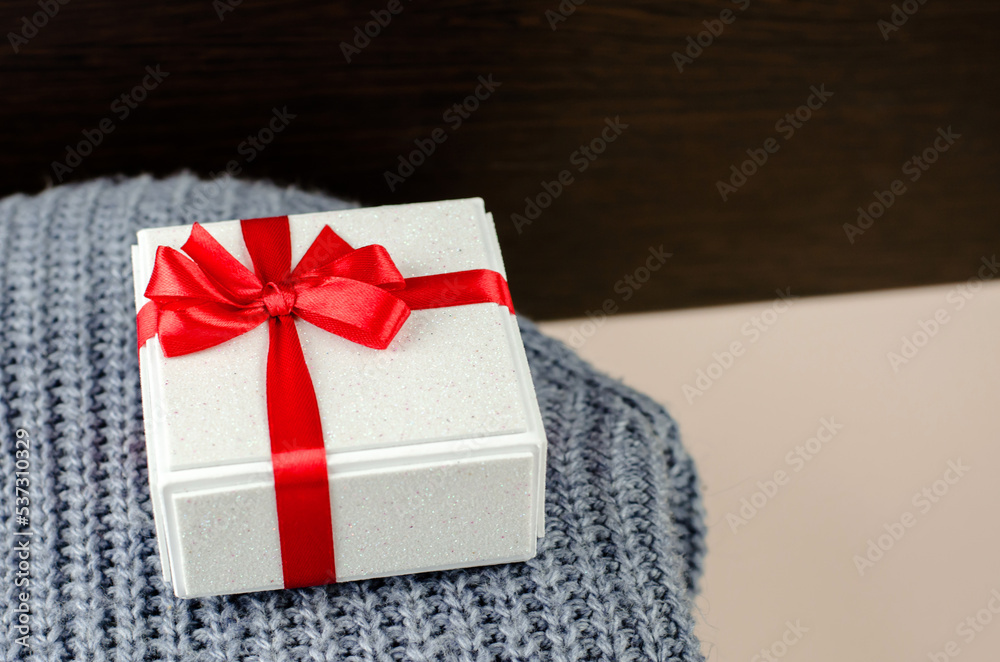 Gift box on a knitted sweater, side view, copy space Gift box on a knitted sweater, side view, copy space
