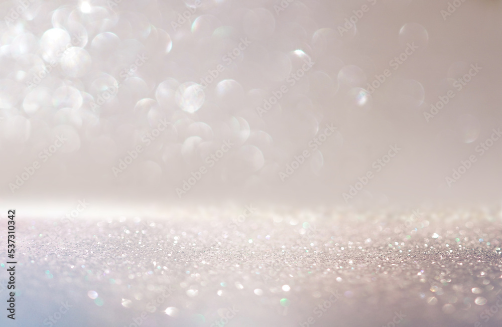 Beautiful festive background image with sparkles and bokeh in pastel pearl and silver colors. Selective focus, shallow depth of field.