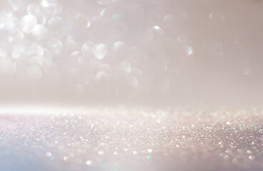 Beautiful festive background image with sparkles and bokeh in pastel pearl and silver colors. Selective focus, shallow depth of field.
