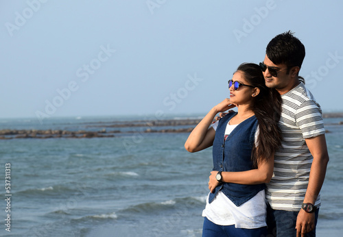 Closeup of a young couple enjoying the beauty of the sea. Romantic pose of Asian couple in honeymoon time.