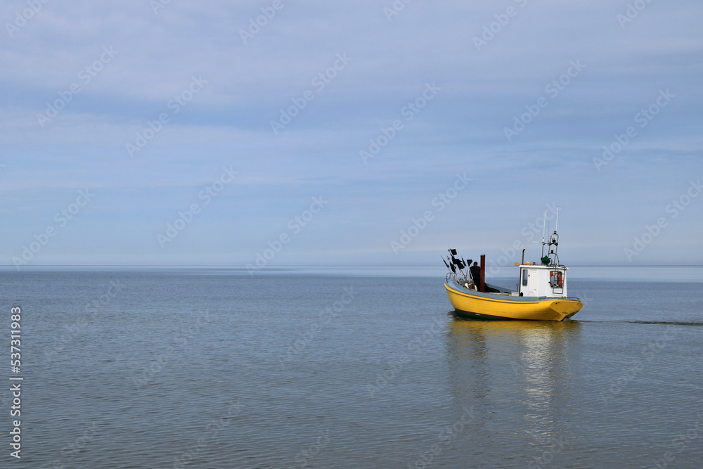 ein gelbes Fischerboot fährt hinaus zum Fischfang