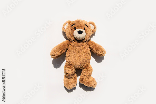 Soft toy bear lies on a white background. Top view, flat lay