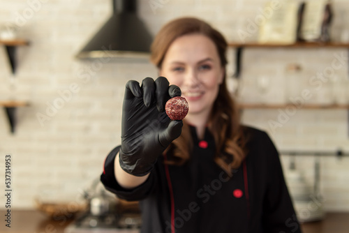 Woman holds candy. Soft focus. Professional pastry chef or chocolatier photo