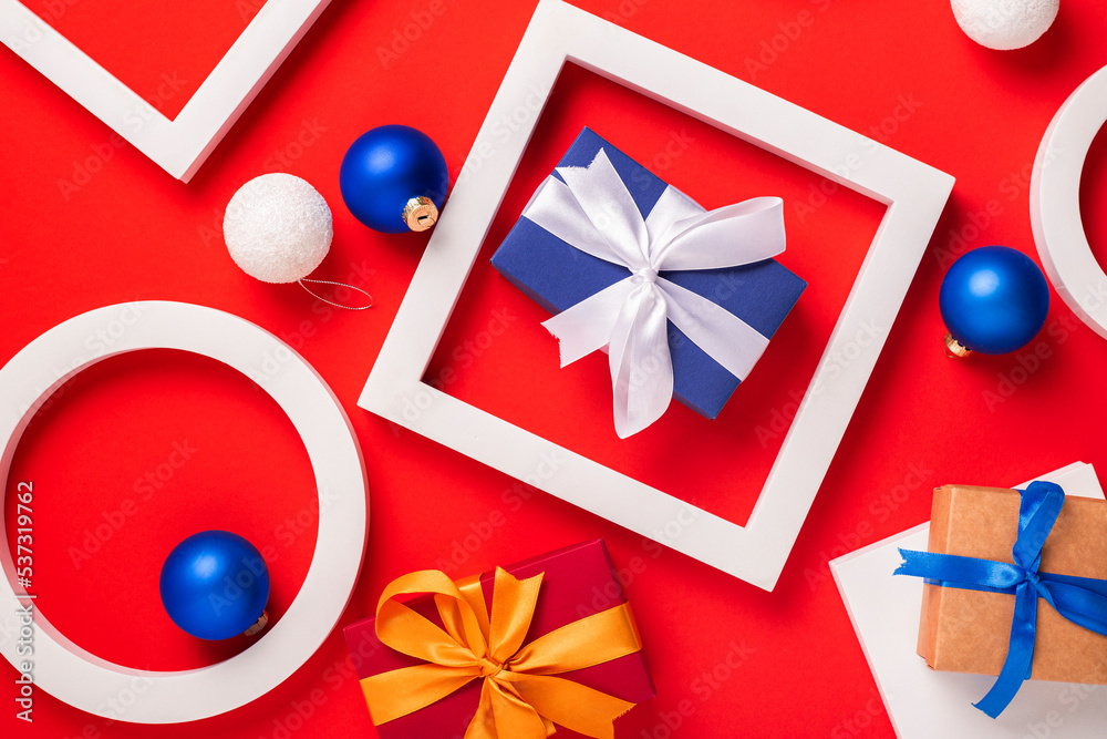 Gifts, podium and Christmas toys on a red background. Top view, flat lay