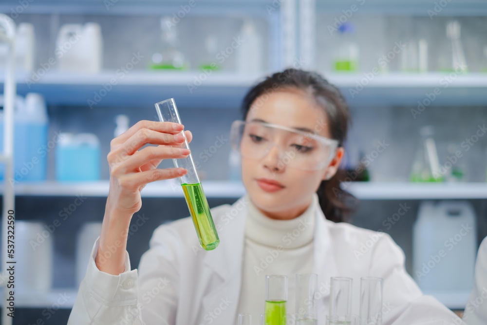 A Female Scientist is holding a test tube or glassware. Concept of laboratory eco or natural cosmetic, medicine, organic skin care. Concept of Eco experiment, botany and studying. Focus on hand. A Female Scientist is holding a test tube or glassware. Concept of laboratory eco or natural cosmetic, medicine, organic skin care. Concept of Eco experiment, botany and studying. Focus on hand.