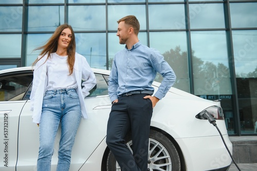 Couple on the charging station for electric vehicles