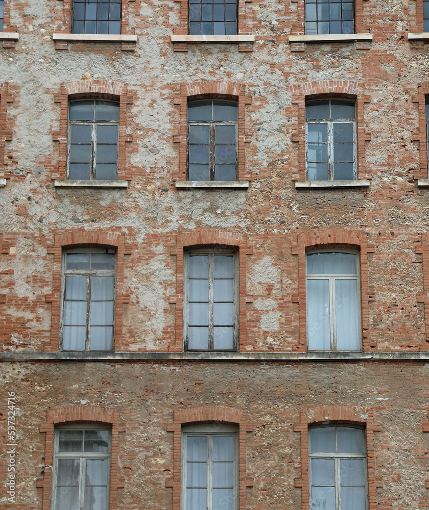 red bricks and old peeling windows of an old industrial building