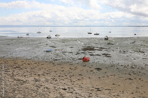 low tide on the ocean and boats aground on the muddy sand