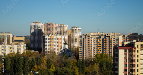 Urban landscape - panoramic view of residential multi-storey modern houses among autumn trees on a sunny October day and copy space © Inna