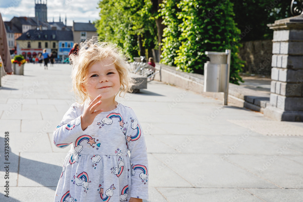 Cute toddler girl with city on background. Happy healthy child and Family and small children vacations in Ireland Cute toddler girl with city on background. Happy healthy child and Family and small children vacations in Ireland