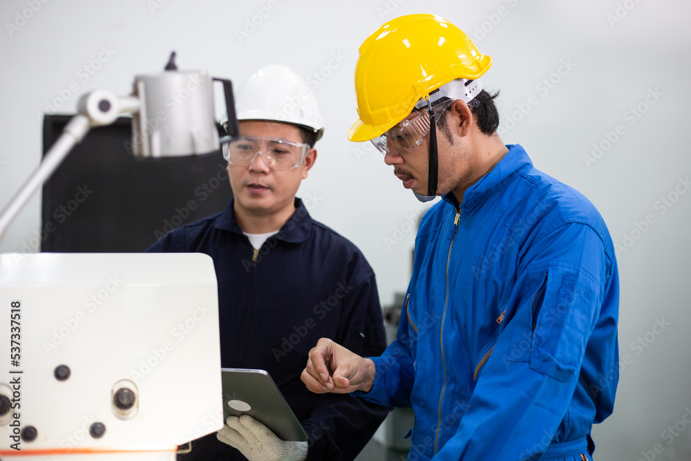 experienced operator technician worker in safety helmet training trainee working for industrial repair on metal machine, professional maintenance skill man in industry manufacturing. experienced operator technician worker in safety helmet training trainee working for industrial repair on metal machine, professional maintenance skill man in industry manufacturing.