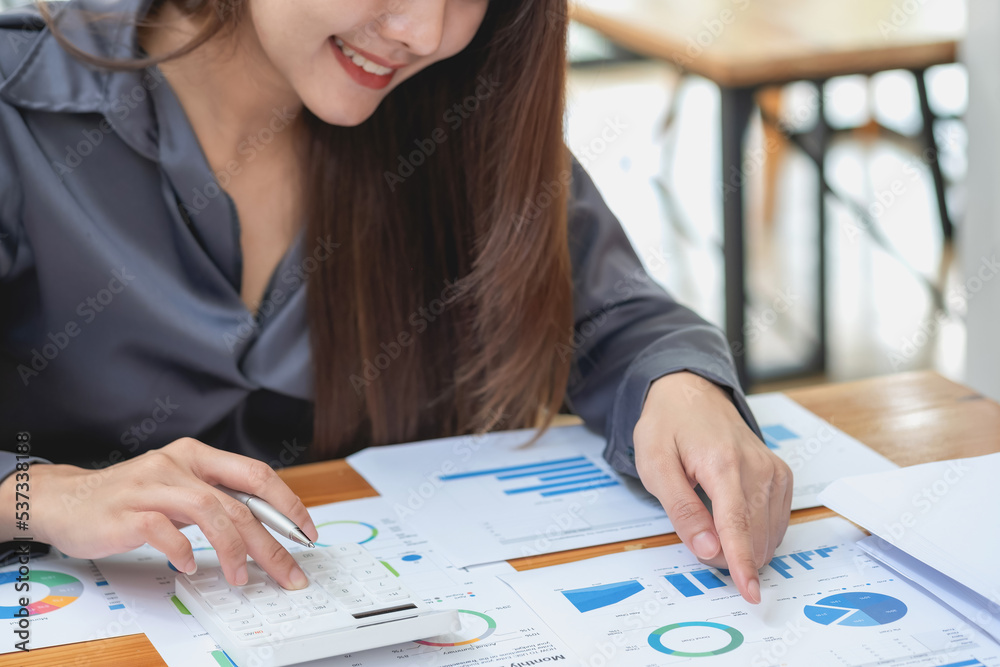 Marketing, Financial, Accounting, Planning, Team of business women analyze company results and profits with graph statistics. Use a laptop computer and a calculator to calculate the company's balance.