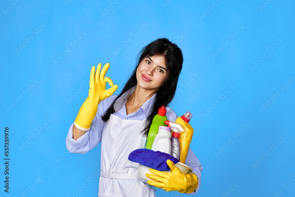 woman in gloves holding bucket of detergents and showing Ok gesture woman in gloves holding bucket of detergents and showing Ok gesture