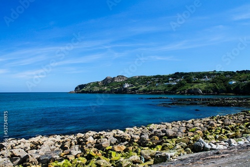 Closeup of Howth Dublin rocky beach with the blue clear sea and sky background, Ireland photo