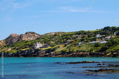 Howth Dublin beach view with the clean sea and forested, green mountains, blue sky background photo