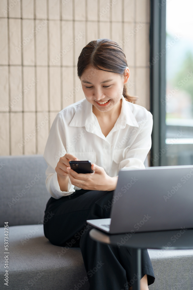 Beautiful Asian woman using smartphone to check work contact customers, answer chats, complete transactions and use social media application. Beautiful Asian woman using smartphone to check work contact customers, answer chats, complete transactions and use social media application.