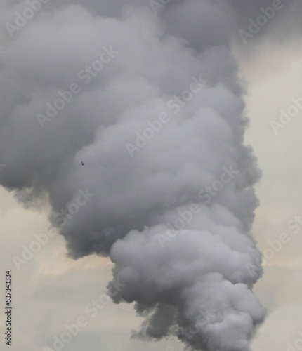 Dangerous smoke against cloudy sky. background.