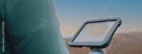 CU on hands, Caucasian male farmer using a tablet while standing in the field. Cloud technology for agriculture. Shot with 2x anamorphic lens
