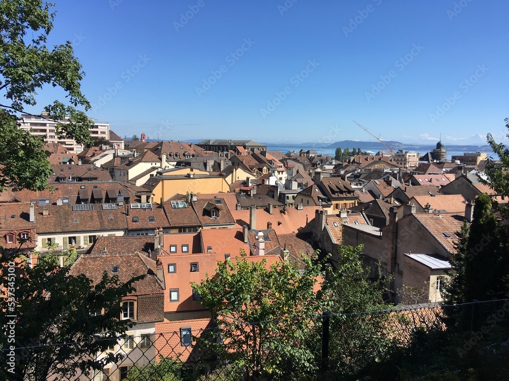 Old buildings, houses in Switzerland Bern rooftops. Old houses red brick roofs with red tiles. Old, historical Bern Switzerland city center. Cobblestone, red brick buildings in town in summer sun day
