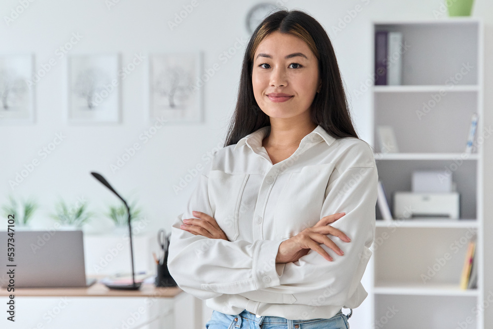 Smiling confident young asian woman standing at home office portrait