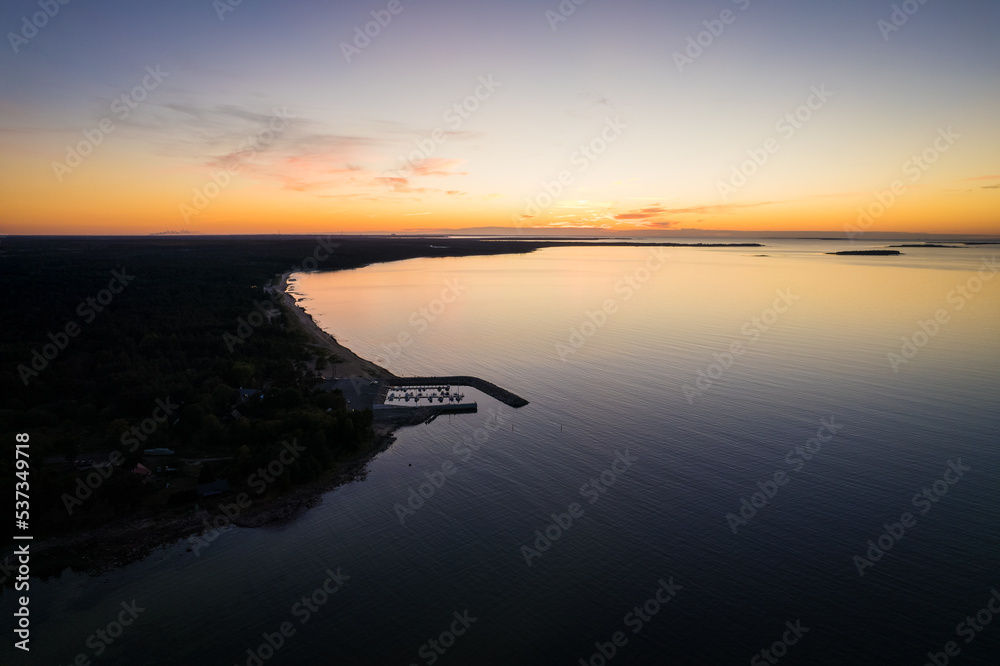 Aerial drone view over small village by the Baltic Sea with small harbor. Magical sunset at seaside port. Aerial drone view over small village by the Baltic Sea with small harbor. Magical sunset at seaside port.