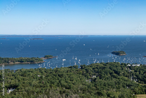 Looking down at the coast of Maine, with sailboats and motor boats moored in the harbor