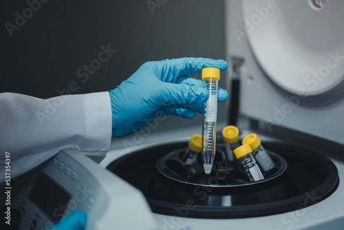 Scientist remove the test tubes of sample extraction from the centrifuge machine after centrifuging for DNA research into the next step. photo