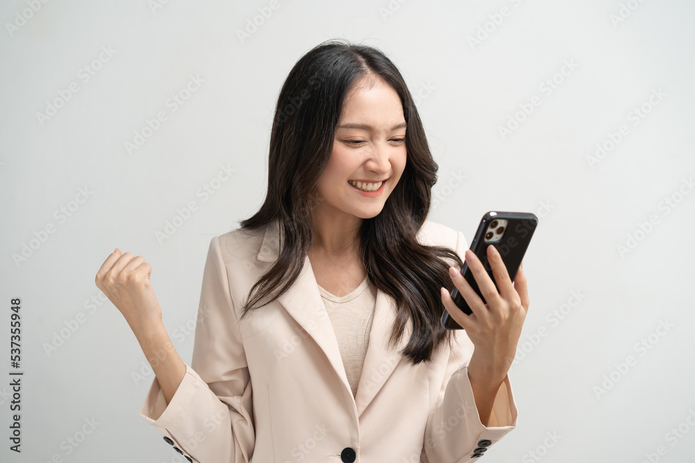 Happy Asian woman holding a smartphone and winning the prize. Happy Asian woman holding a smartphone and winning the prize.