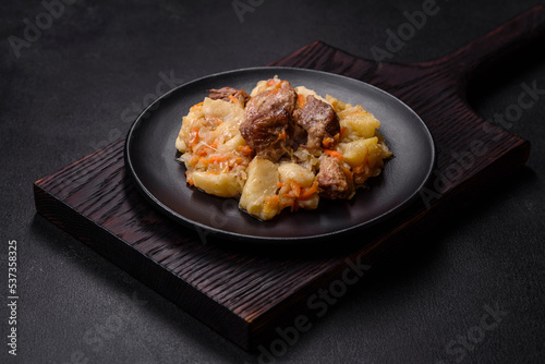 Delicious vegetable stew with beef, potatoes, carrots and cabbage in a black plate