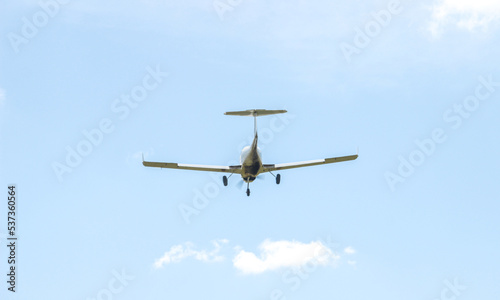 A single-engine plane is flying in the sky among the clouds. A light-engine plane in the blue sky flies through the clouds.
