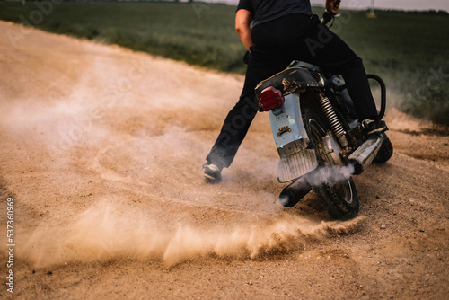 motorcyclist drifting on a retro motorcycle on a sandy road, motocross training.
