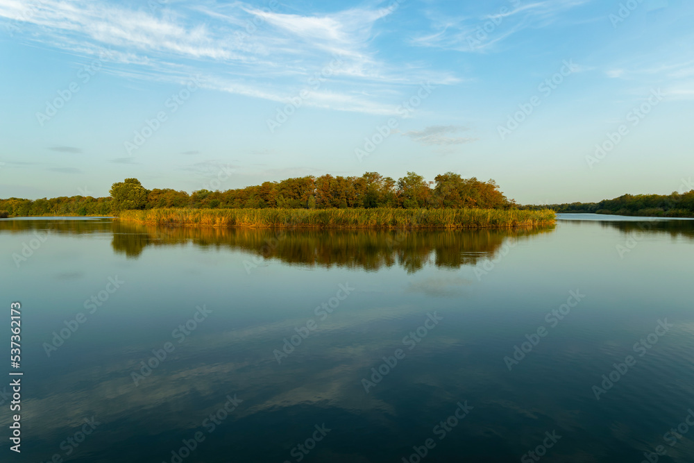 Sunny spring morning on the river bank. Picturesque rural landscape. Summer sunny background.