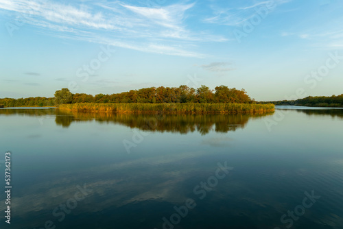 Sunny spring morning on the river bank. Picturesque rural landscape. Summer sunny background.