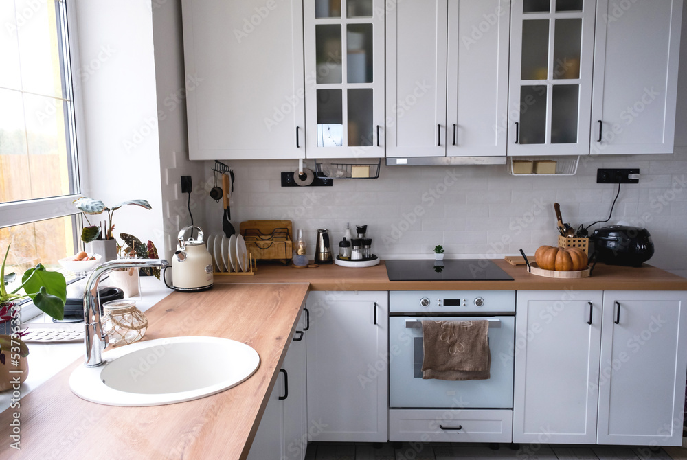 White cozy kitchen in Scandi loft style. Home interior, dining room design, oven, hob, table, kitchen furniture White cozy kitchen in Scandi loft style. Home interior, dining room design, oven, hob, table, kitchen furniture