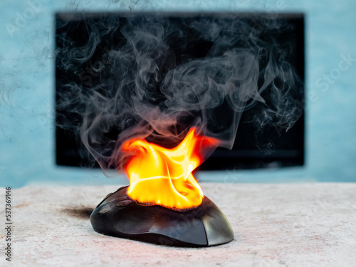 Computer mouse in flames. Careless handling of equipment, fire