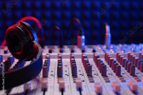 Headphones on sound mixer with faders and music cable jack. Audio equipment in record studio