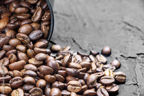 Roasted coffee beans in metal cup on a black background.Copy space.