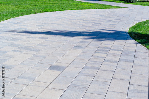 concrete path in the park with a lawn on the edges