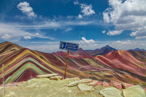On the top of the Rainbow Mountains stands the sign with the height and name of the mountain: Vinicunca photo