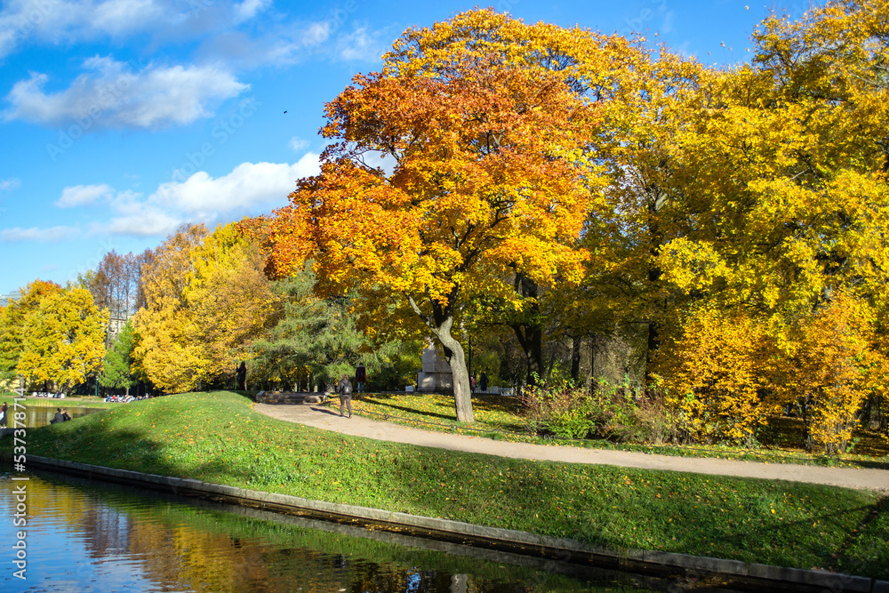 Beautiful trees with yellow and orange foliage in the autumn park on the banks of the pond Beautiful trees with yellow and orange foliage in the autumn park on the banks of the pond
