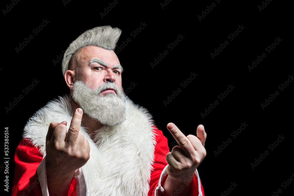 Φωτογραφία Portrait of a brutal mature Santa Claus with mohawk showing middle finger signs, isolated on black background