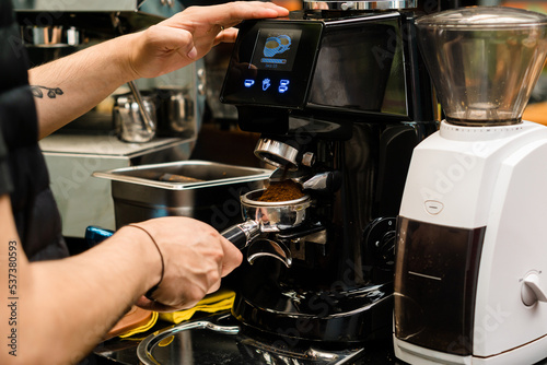 Hands of a barista making coffee in an espresso machine. © Daniel